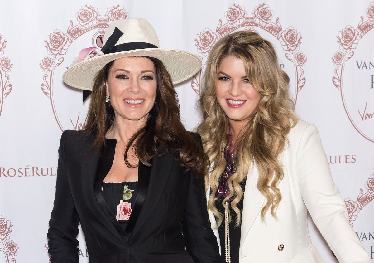 Lisa Vanderpump smiling in white hat and black dress, Pandora Sabo beside her smiling in white jacket