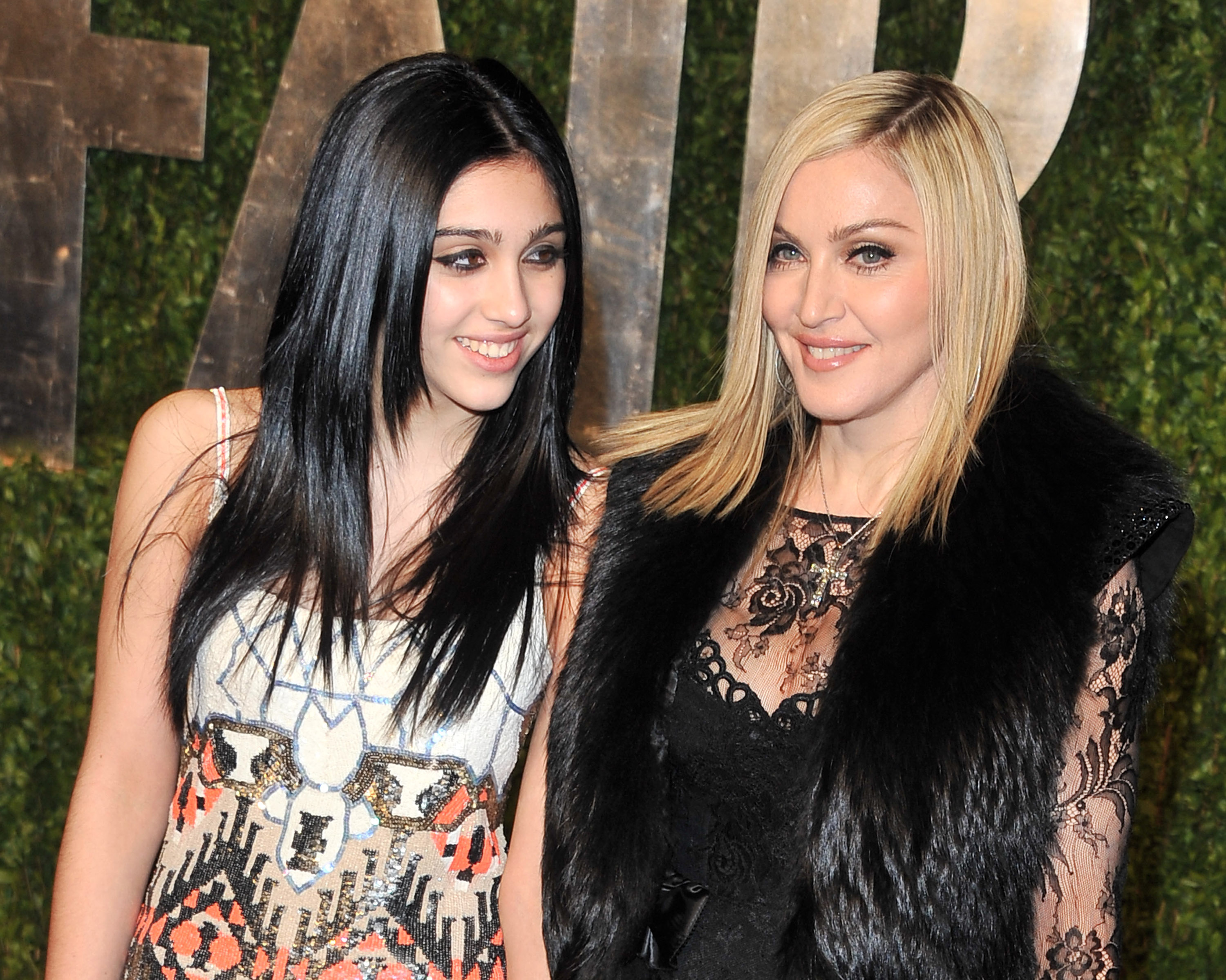 Lourdes Leon wears a multi-colored dress and Madonna wears a black dress and fur vest.