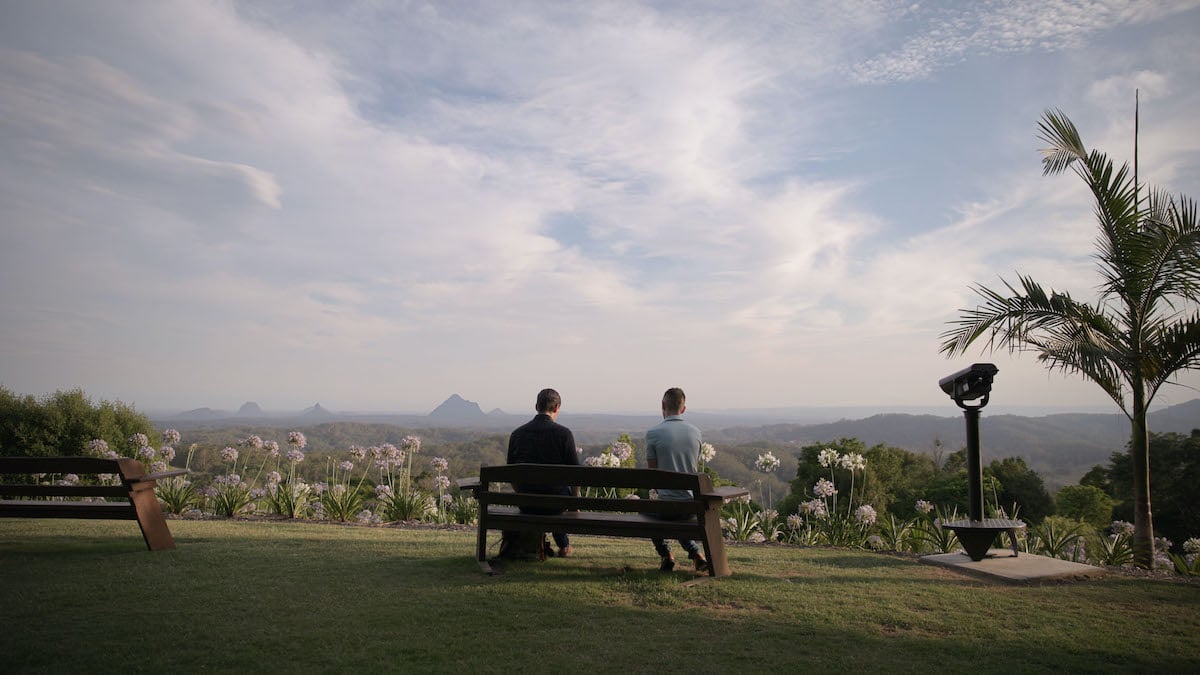 'Love on the Spectrum' episode still showing a couple on a bench in front of a mountain