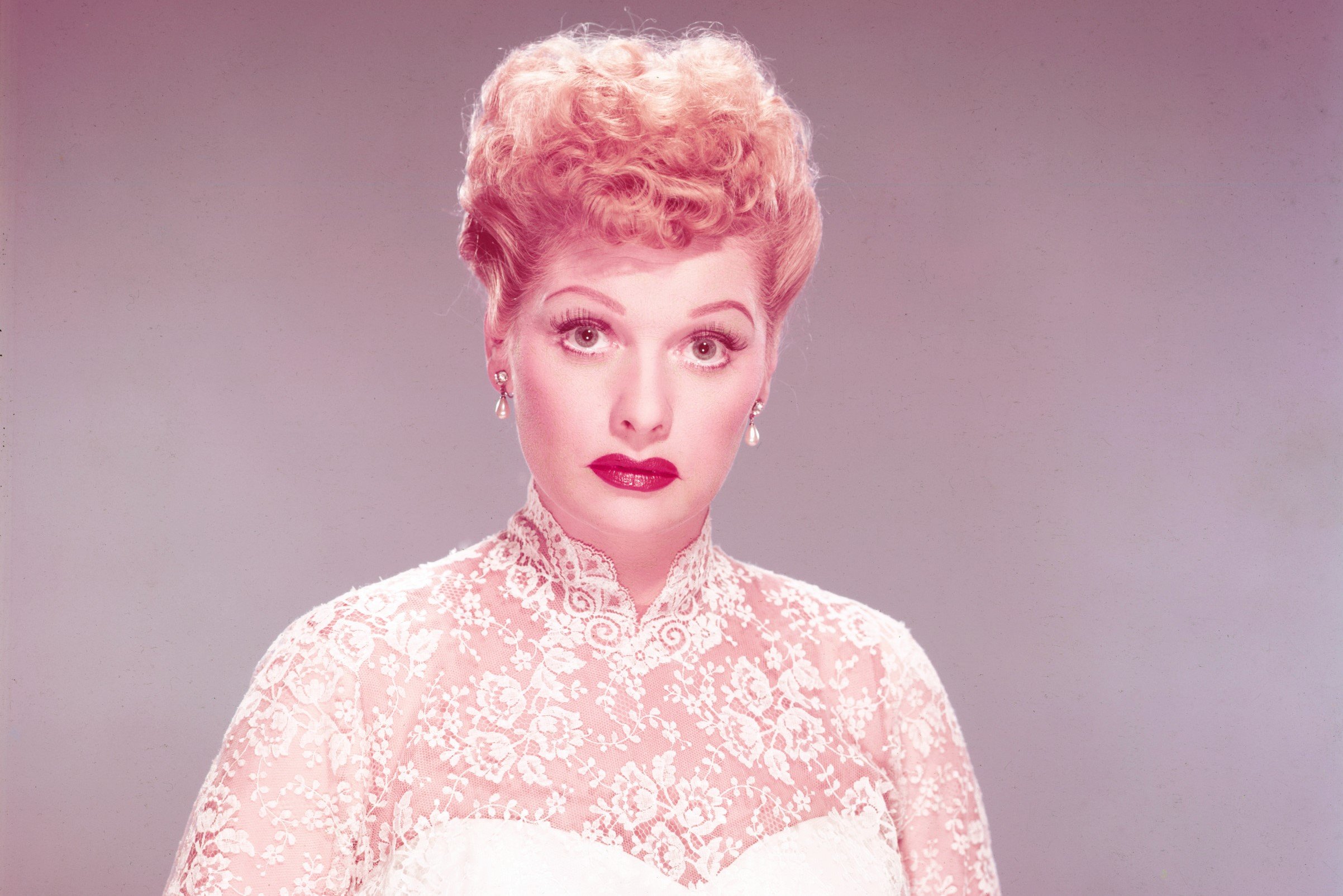 Lucille Ball wearing a white lace wedding dress, circa 1955.