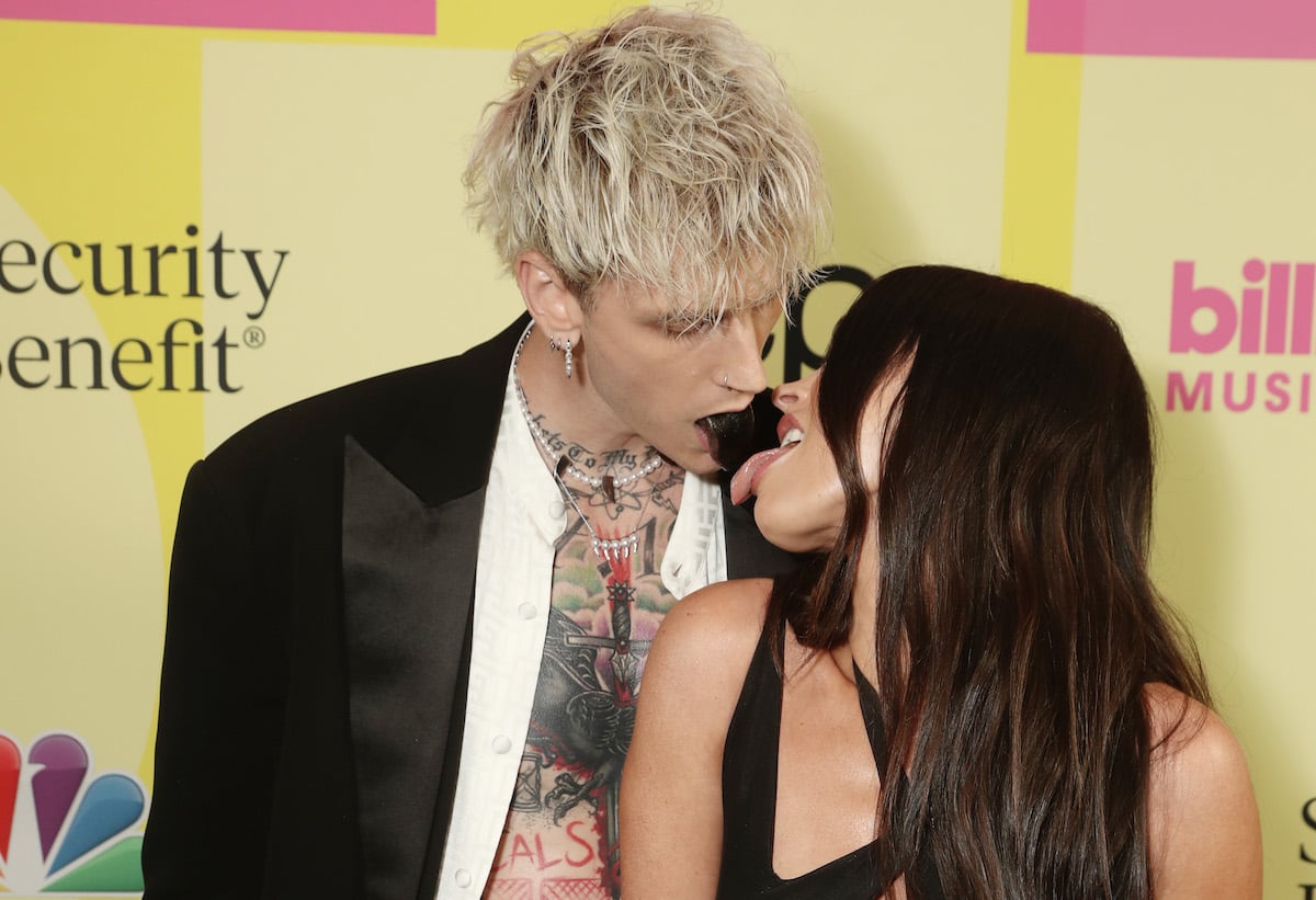 Machine Gun Kelly and Megan Fox touch tongues at an event.