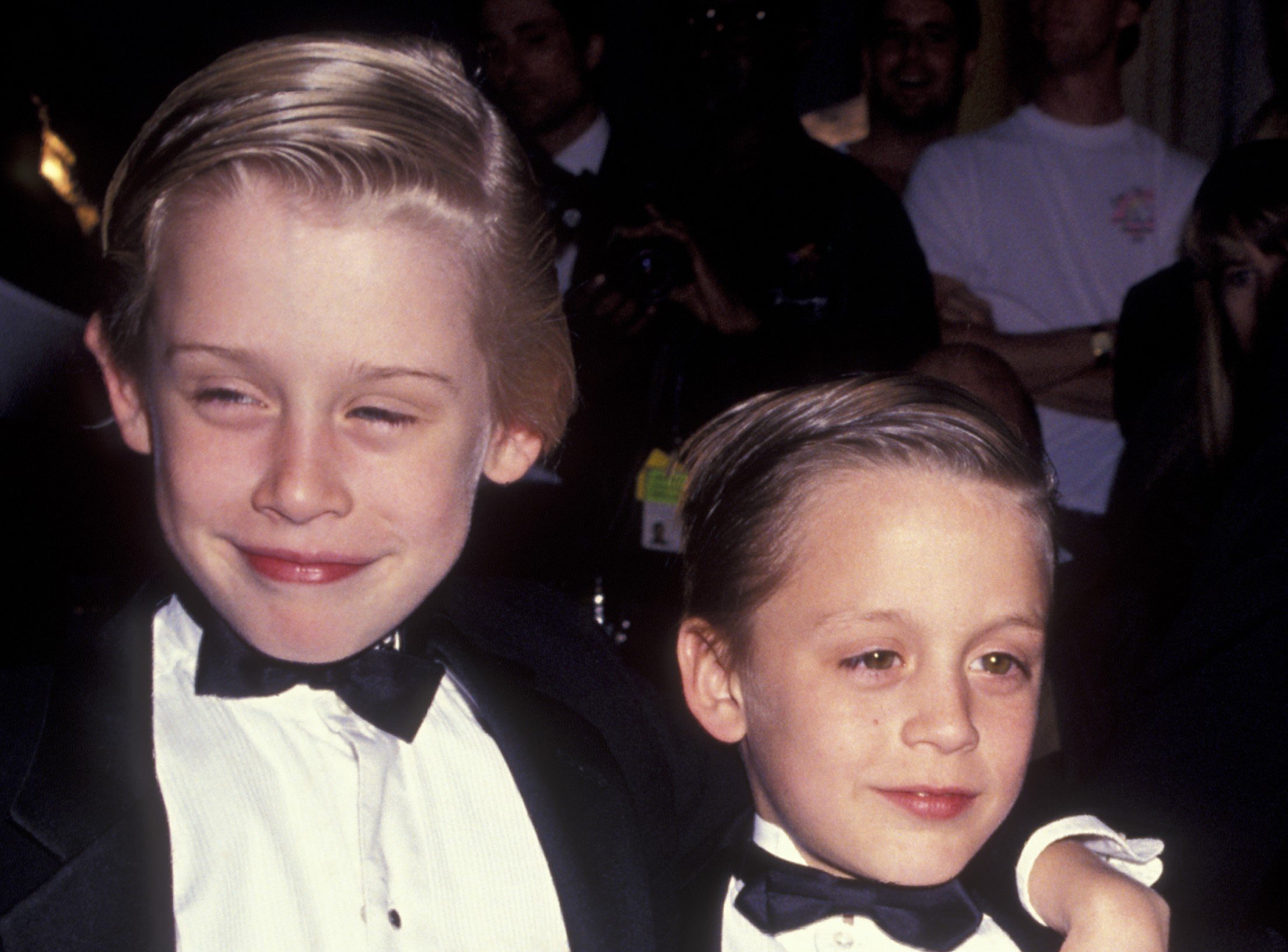 Macaulay Culkin and Kieran Culkin as children wearing tuxedos.