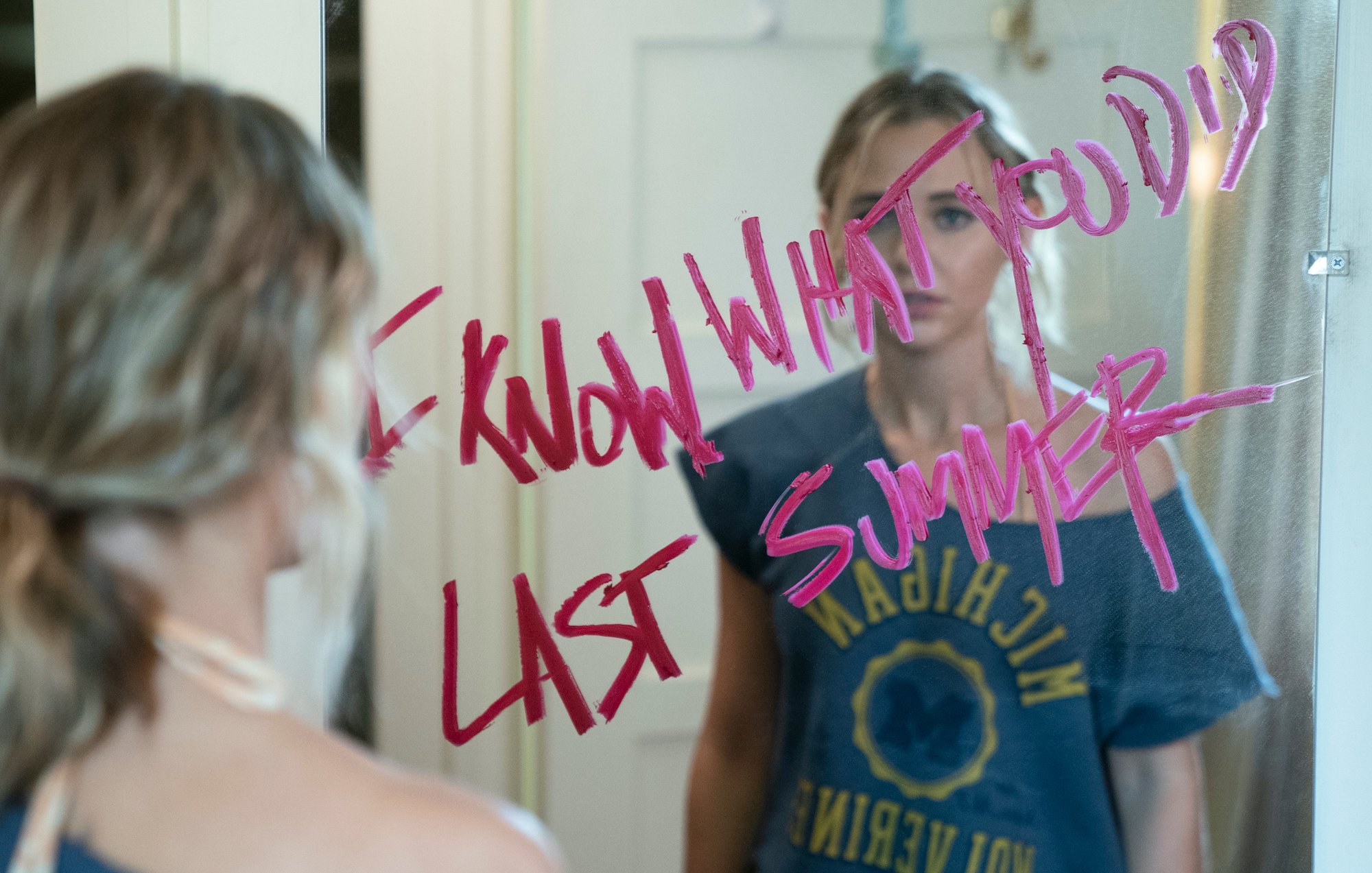 Madison Iseman looks into a mirror with lipstick that reads 'I Know What You Did Last Summer' in a still from the Amazon Prime series