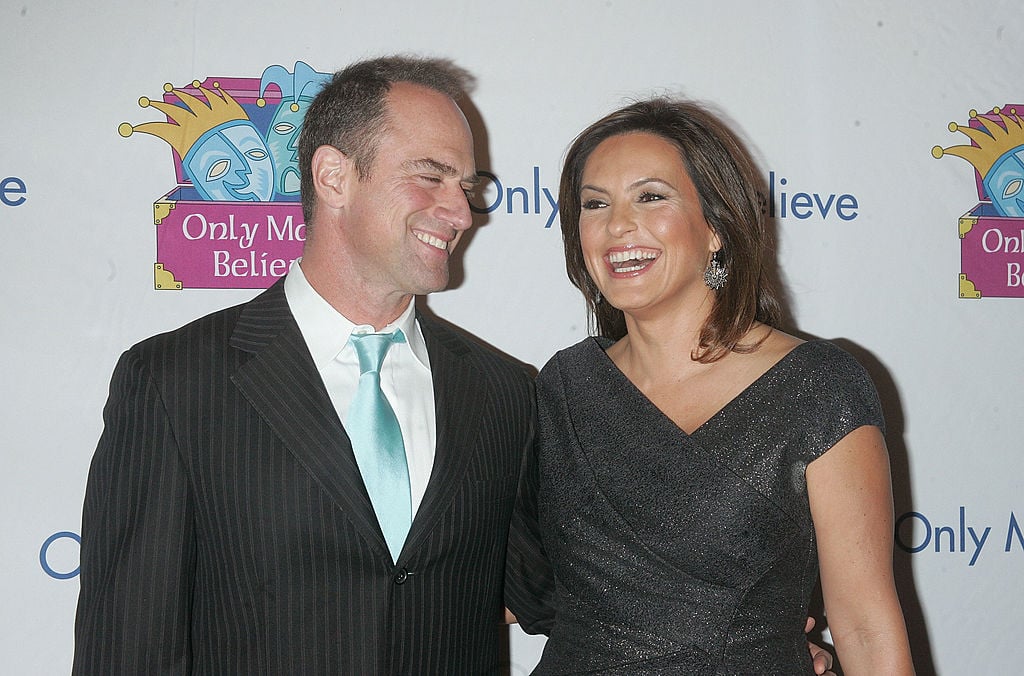 Mariska Hargitay and Christopher Meloni  pose on the red carpet together. Both are laughing.