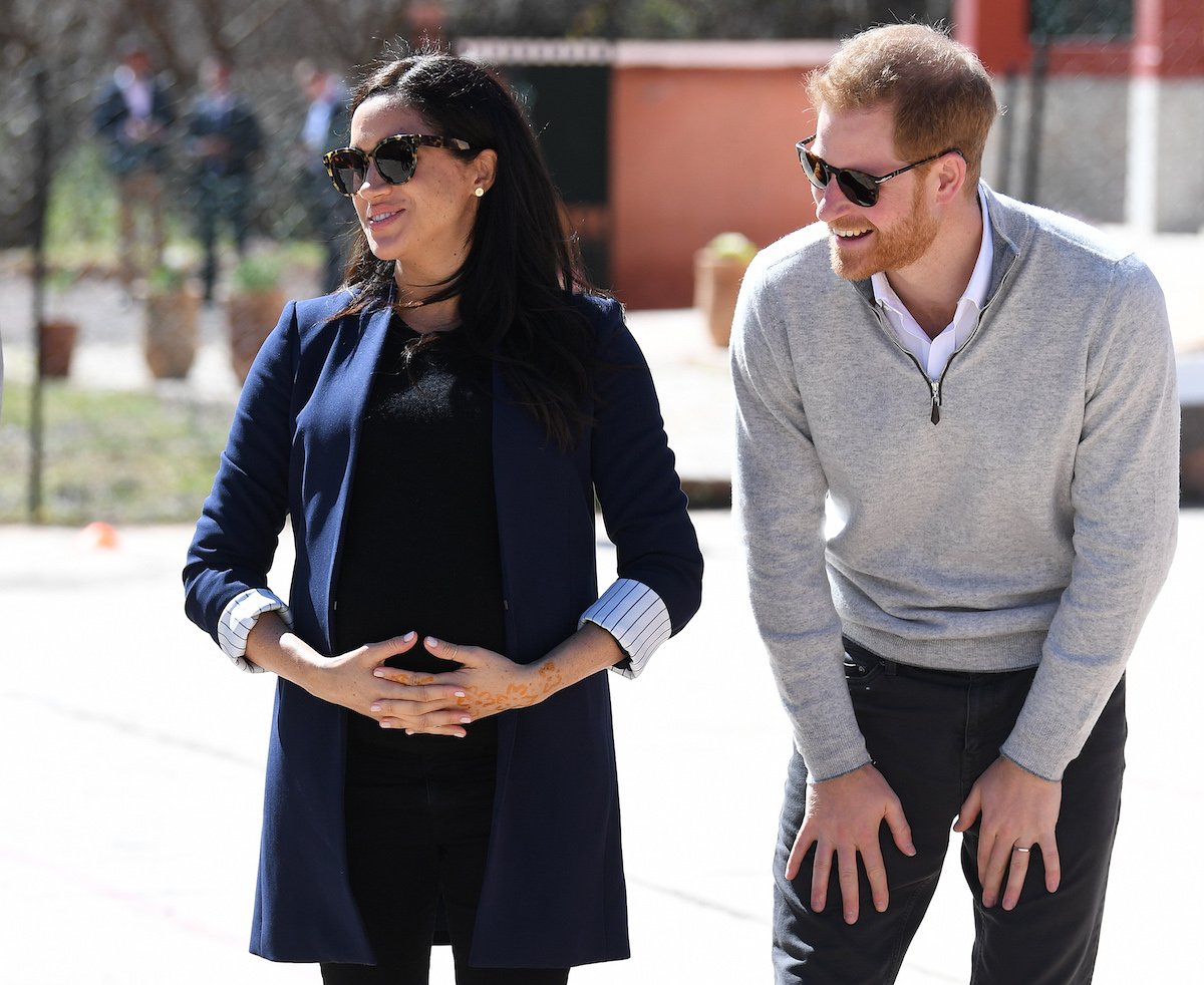Meghan Markle pregnant, smiling, standing next to Prince Harry