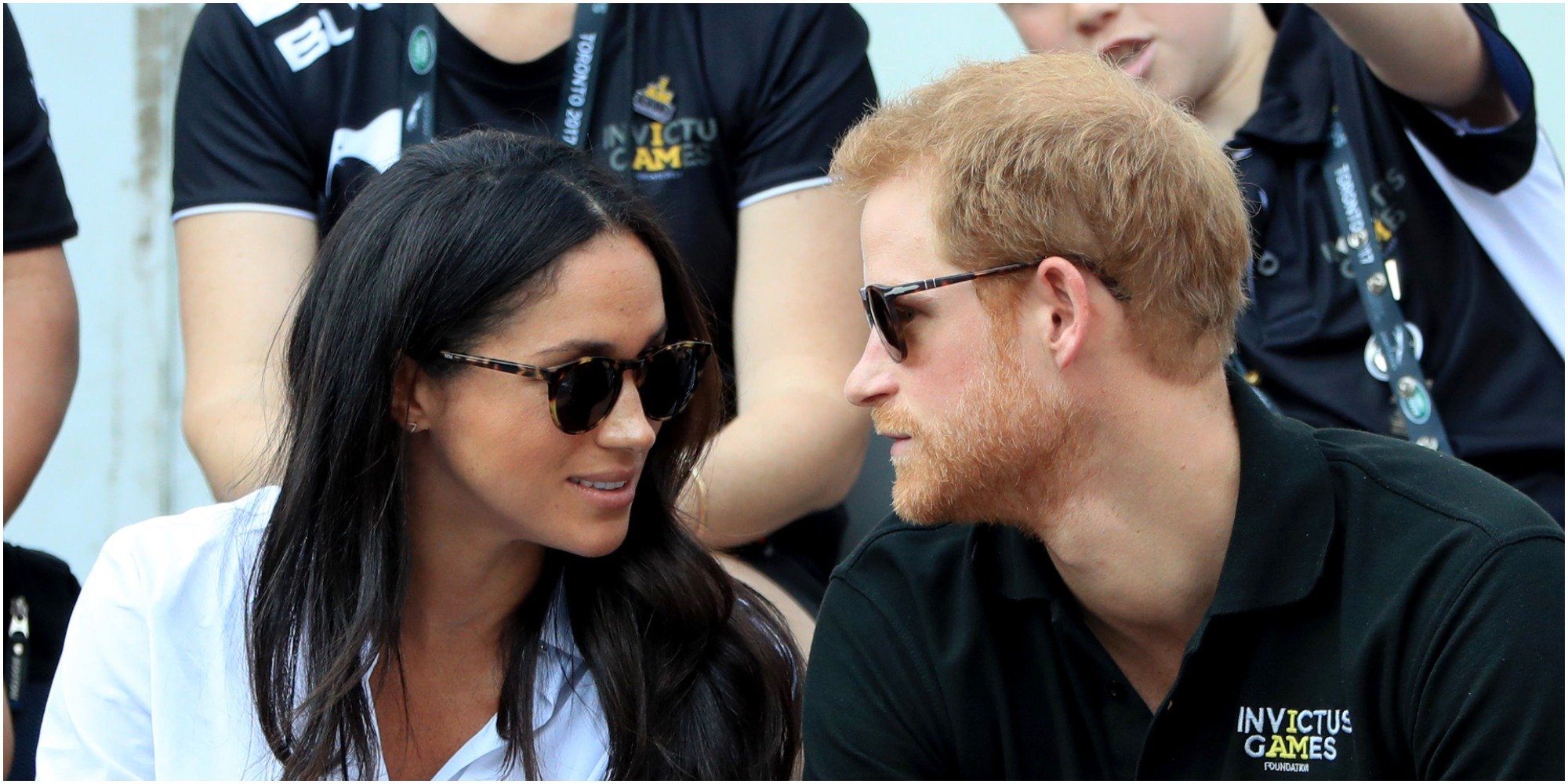 Meghan Markle and Prince Harry wearing sunglasses and talking to each other