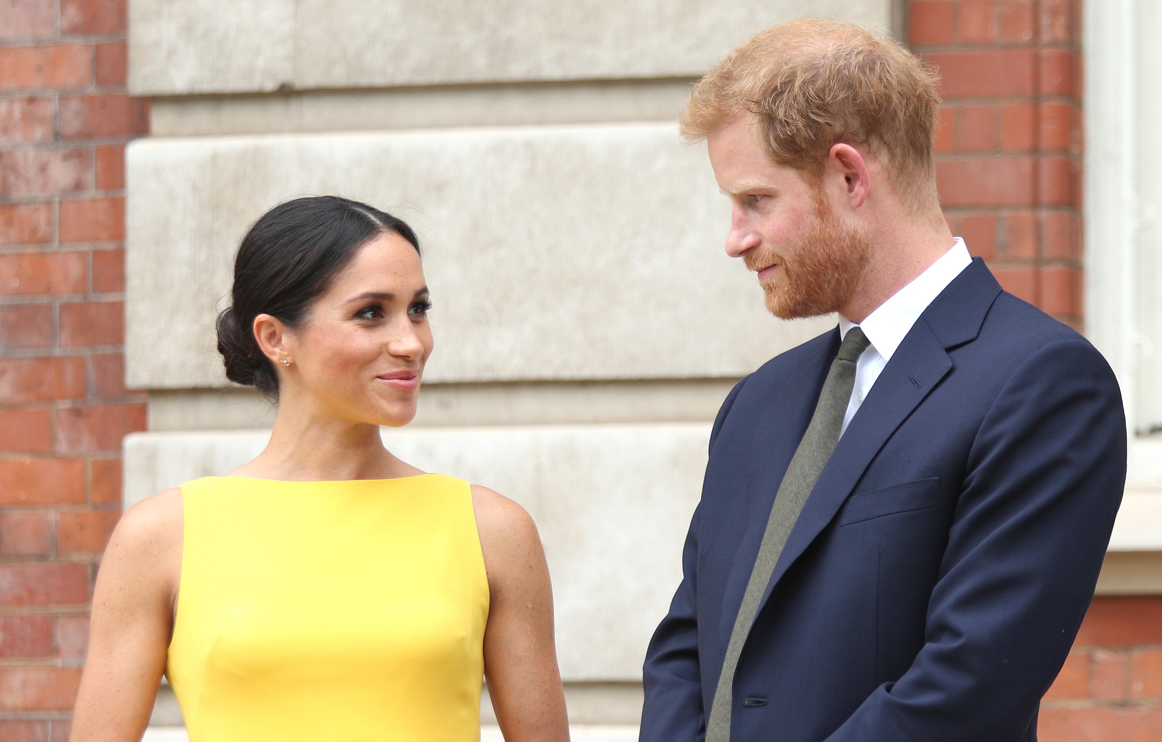 Meghan Markle dressed in yellow and Prince Harry in a navy suit at Commonwealth Youth Challenge reception
