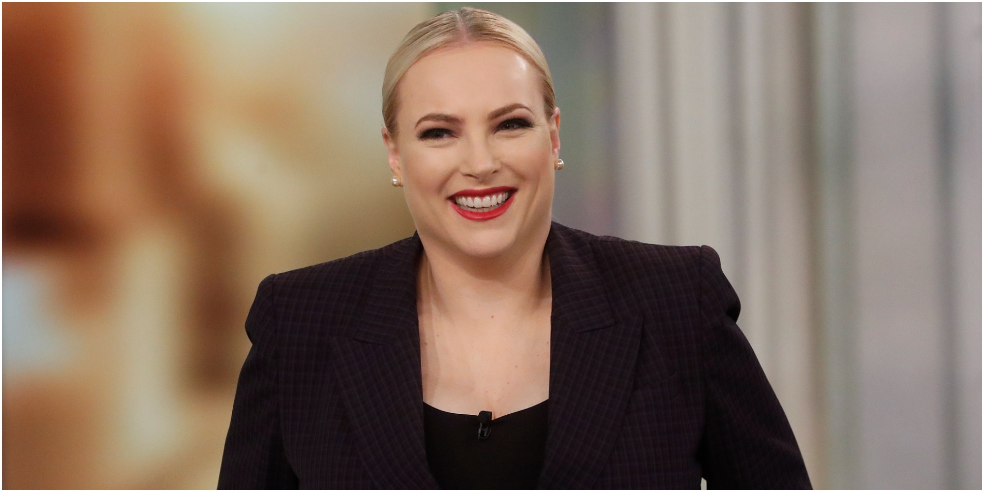 Meghan McCain on the set of The View wearing a black jacket.