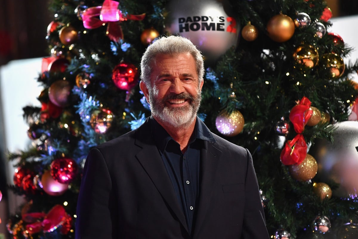 Mel Gibson smiling in front of Christmas tree