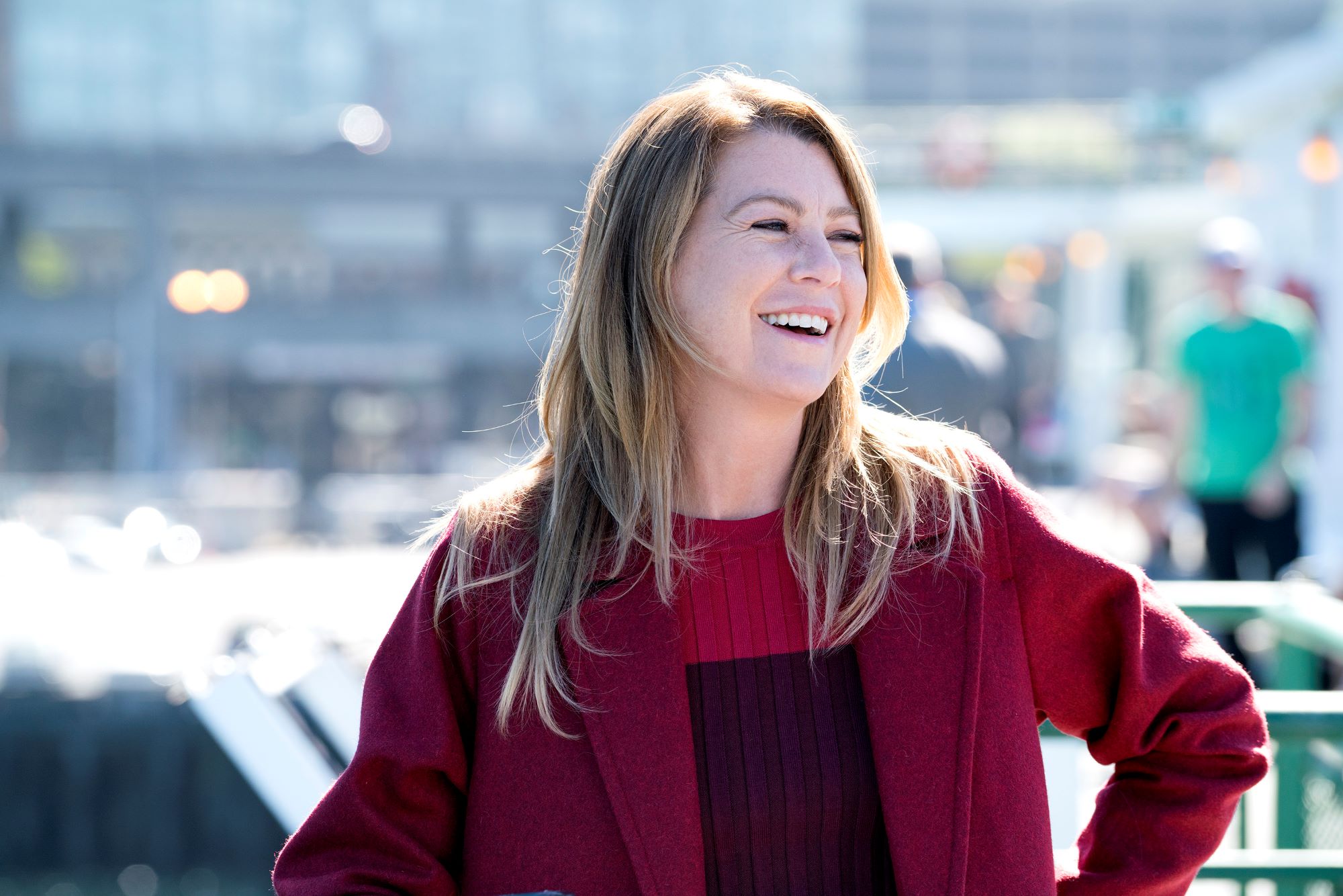 Meredith from 'Grey's Anatomy' dressed in a red coat and black shirt.