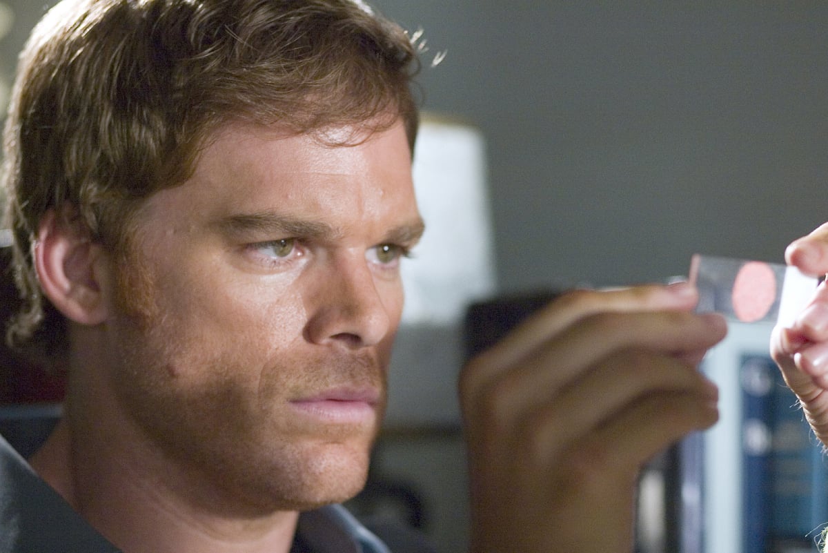 Dexter Morgan lifts up a blood slide to look at in season 1 of 'Dexter.'