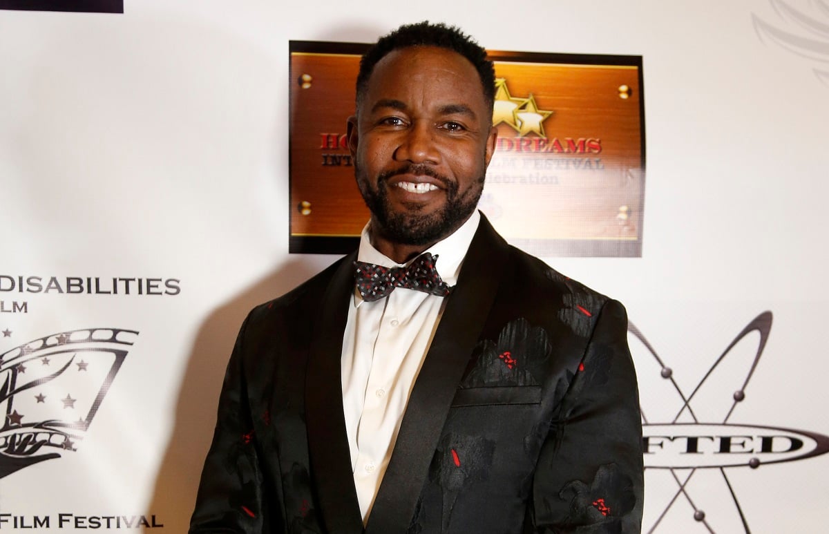 Michael Jai White smiling in a suit