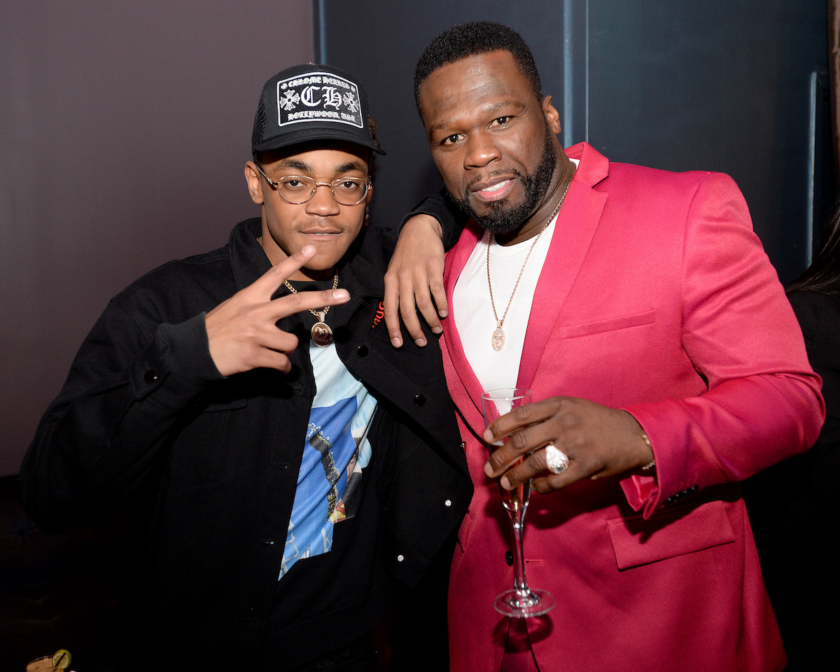 Michael Rainey Jr. and Curtis "50 Cent" Jackson posing on the red carpet, Rainey has his two fingers up while 50 Cent holds a glass wearing a pink jacket