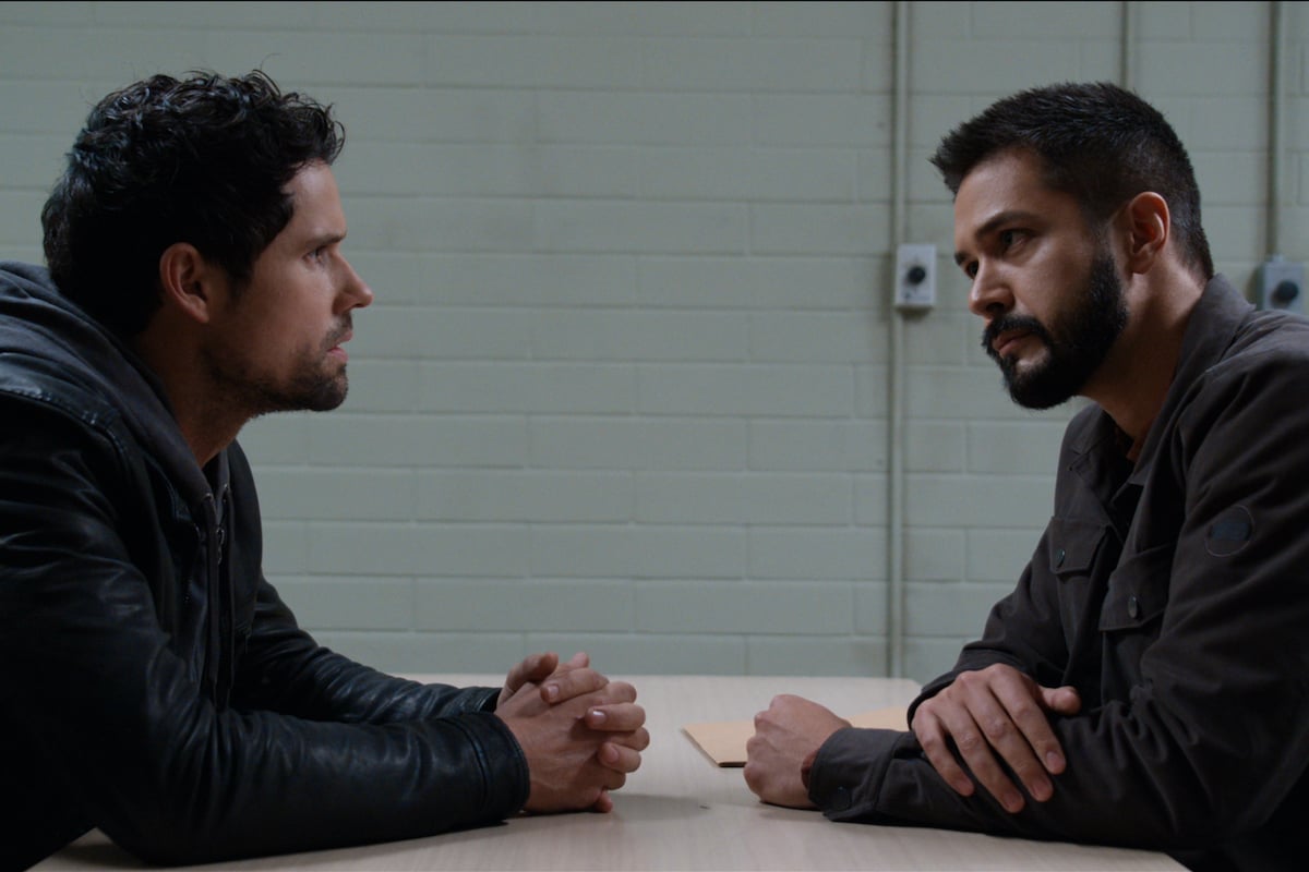 Benjamin Hollingsworth as Dan Brady and Marco Grazzini as Detective Mike Valenzuela sitting at an interrogation table in ‘Virgin River’