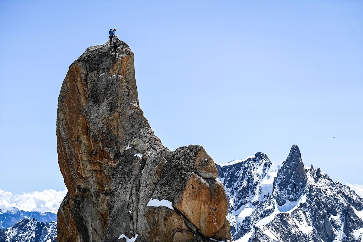 Mountaineer on top of a large rock near Mont Blanc mountain between France and Italy