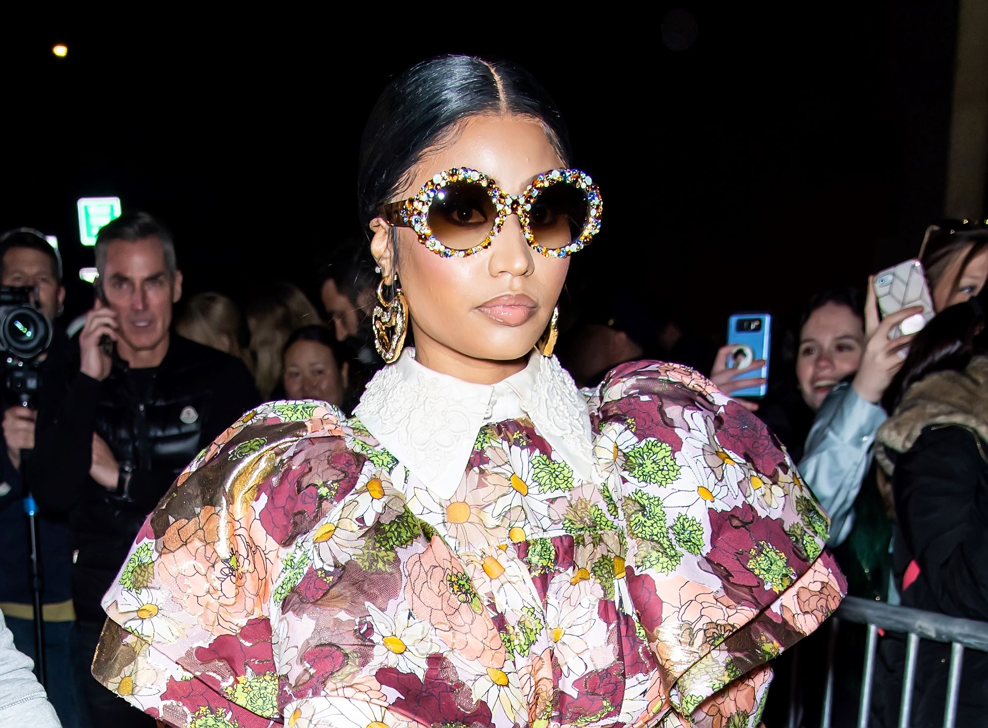 Nicki Minaj wearing a floral puffy shoulder top with diamond studded large rim glasses.