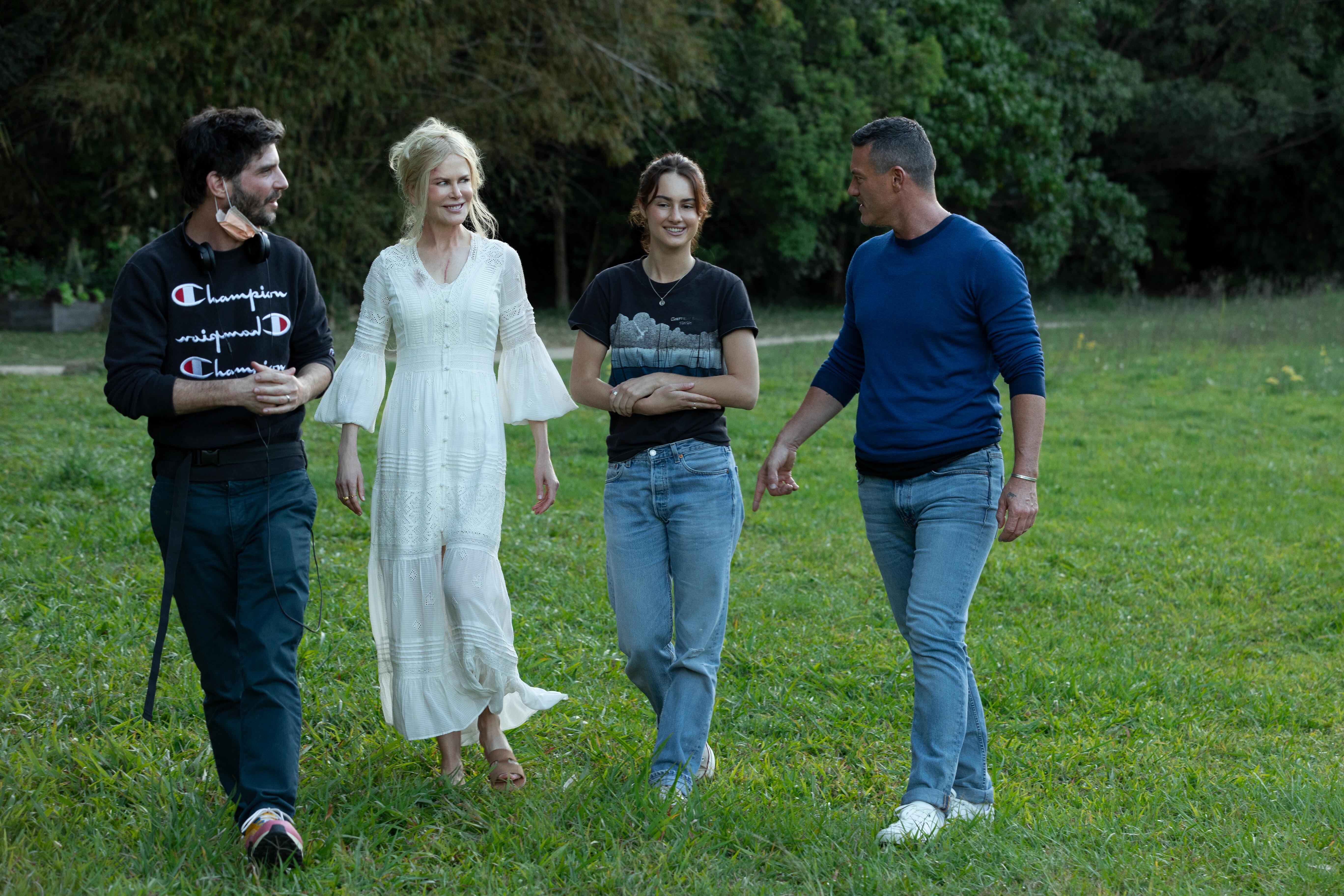 Nine Perfect Strangers director Jonathan Levine walks with Nicole Kidman, Grace Van Patten, and Luke Evans. They are smiling and talking.