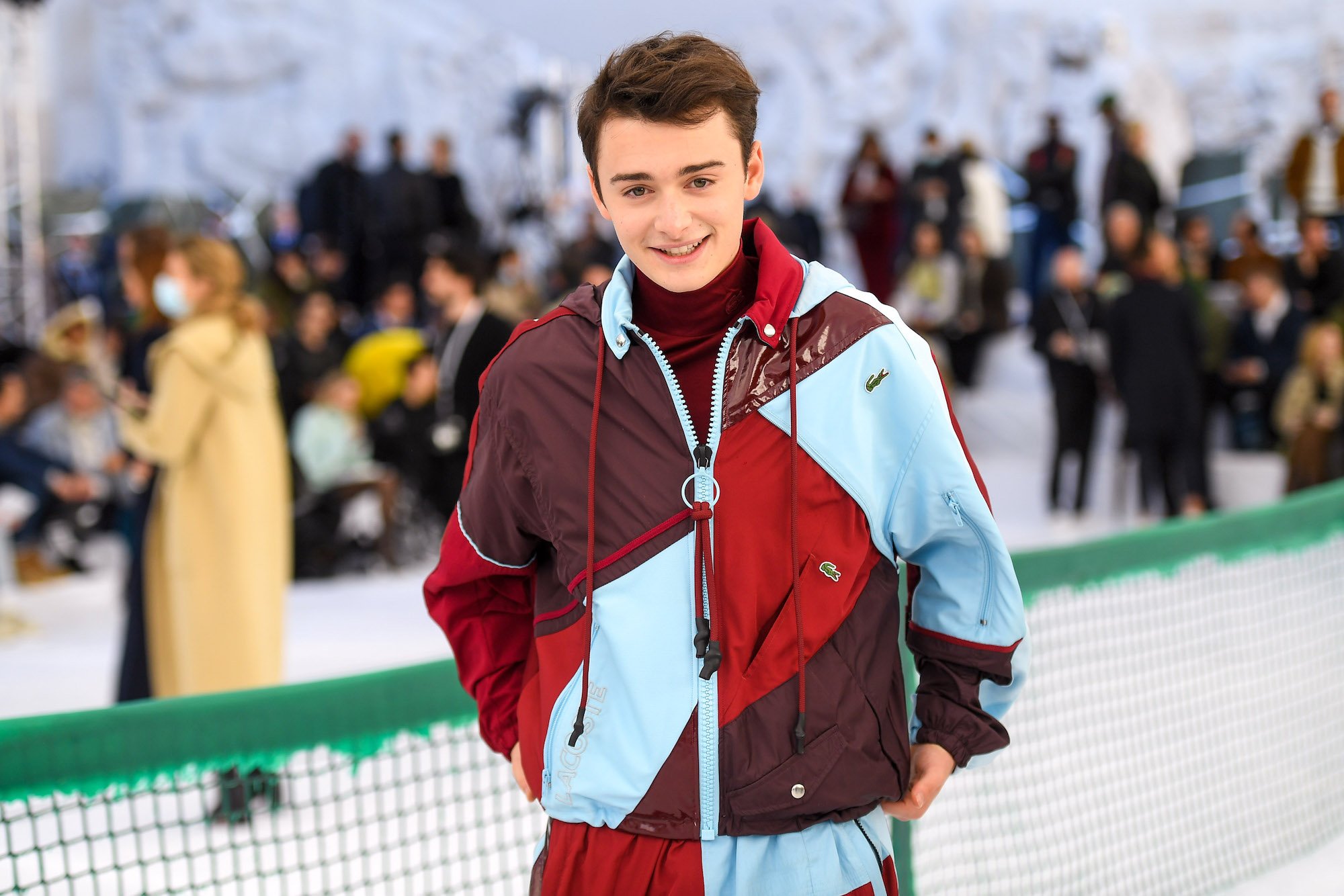 Noah Schnapp, star of 'Stranger Things,' in a blue and burgundy jacket while attending Fashion Week in Paris.