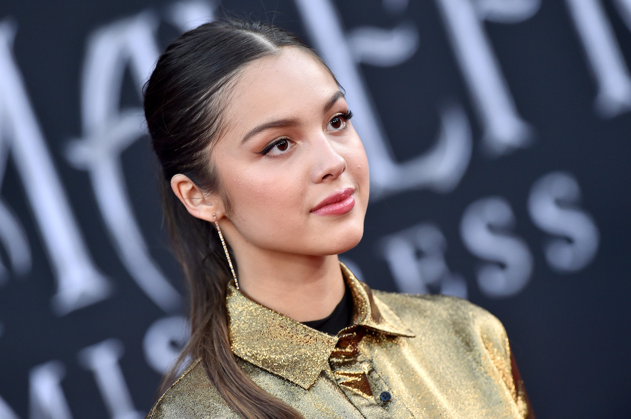 Olivia Rodrigo wearing a ponytail in front of dark background