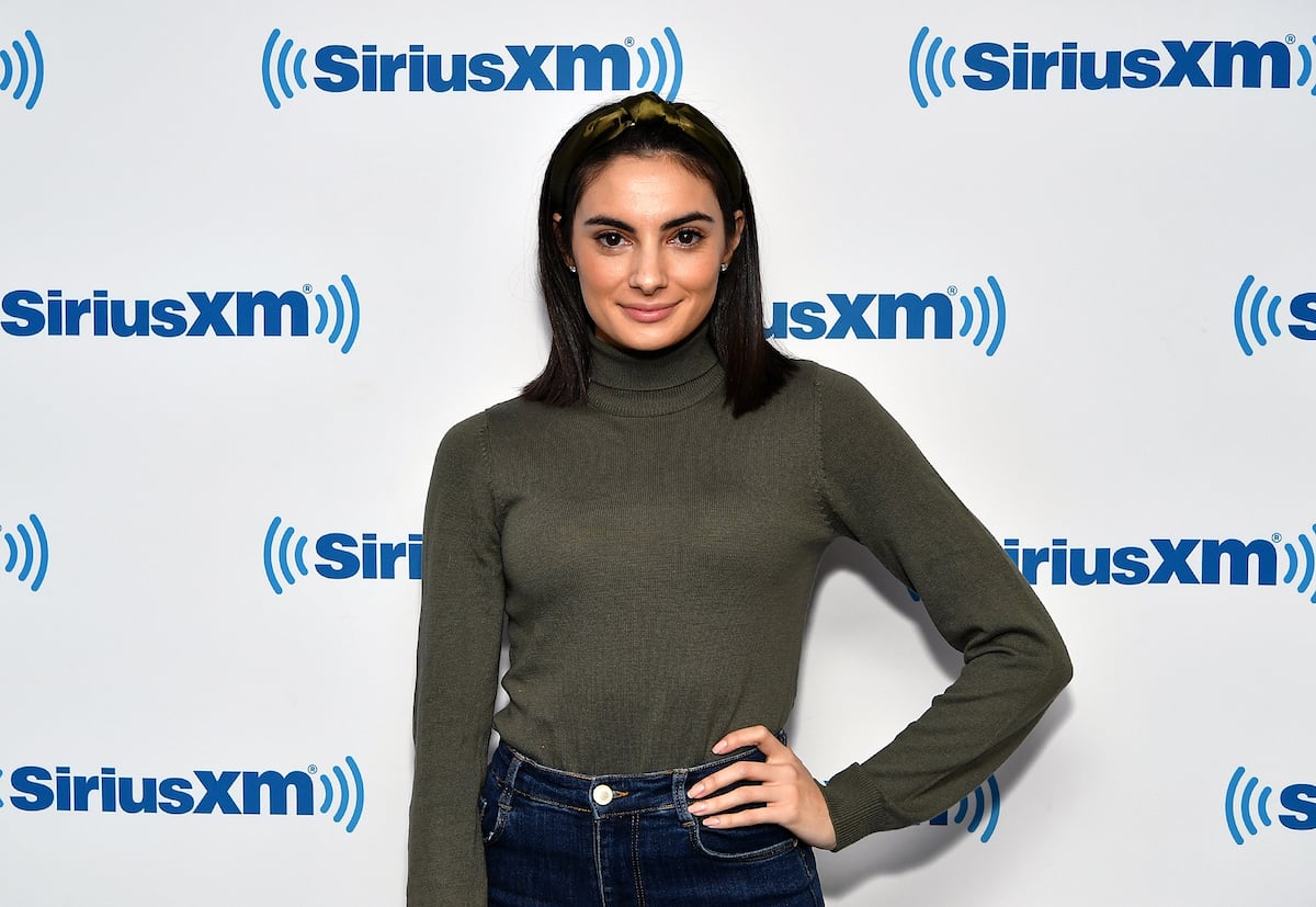 Paige DeSorbo from "Summer House" poses in a turtleneck and jeans at an event.