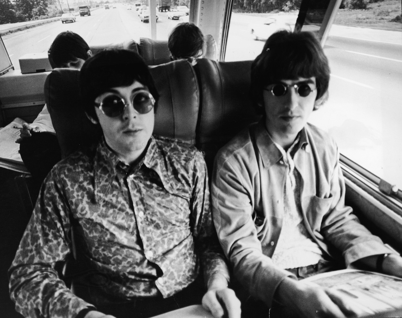 Paul McCartney and George Harrison on a tour bus in 1966.