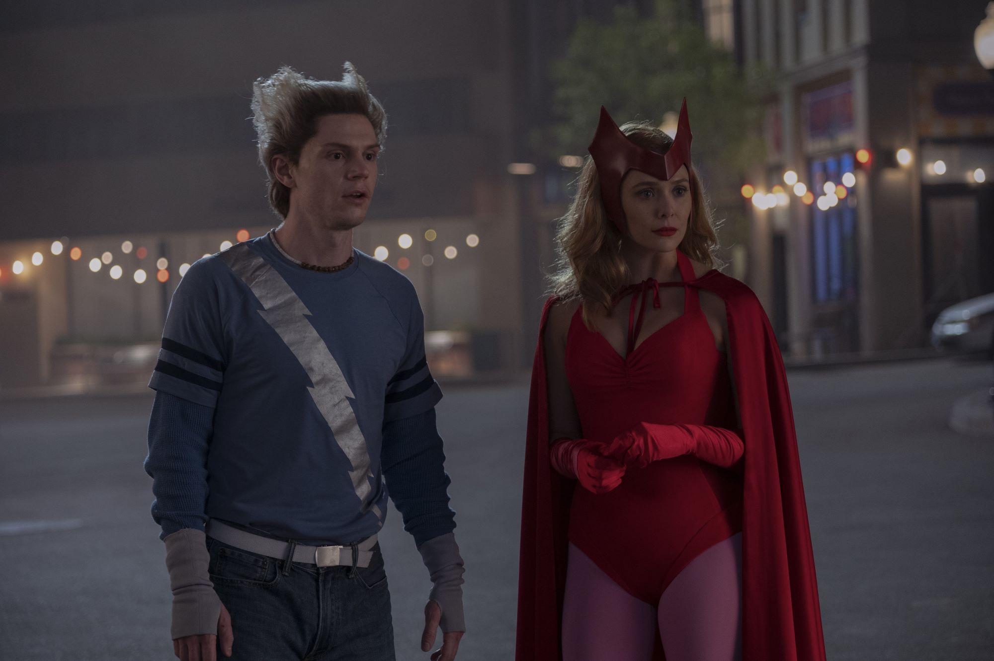 'WandaVision' stars Evan Peters and Elizabeth Olsen, in character as Pietro and Wanda Maximoff, wear Halloween costumes. Pietro is dressed in his original Quicksilver comic book costume. Wanda is dressed in her original Scarlet Witch comic book costume.