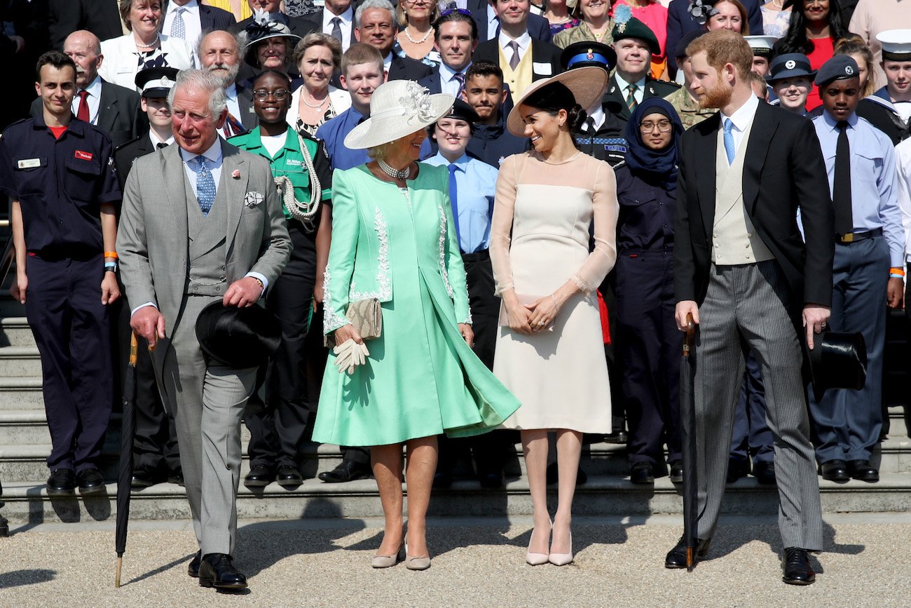 Prince Charles, Camilla Parker Bowles, Meghan Markle, and Prince Harry stand in front a crowd at a birthday celebration for Prince Charles in 2018