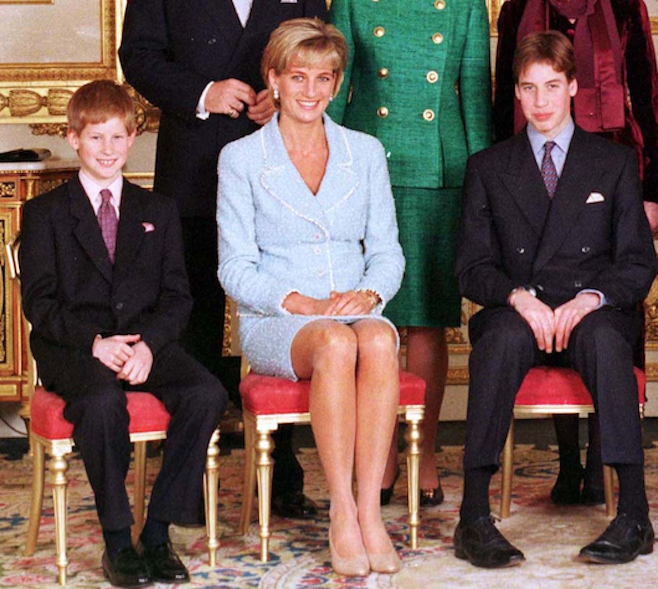 Prince Harry, Princess Diana, and Prince William smile as they sit in chairs posing for photographers following Prince William's confirmation