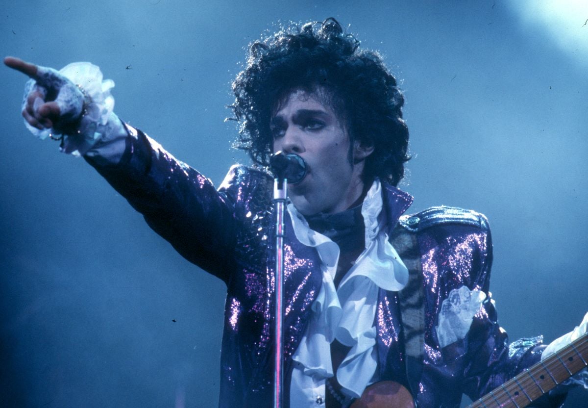 Prince wearing a ruffled shirt and sequined jacket.