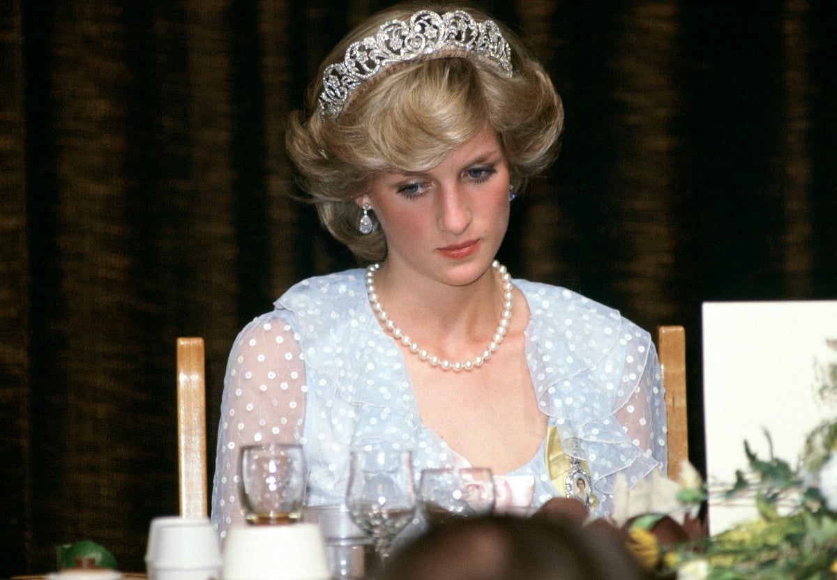 Princess Diana at a banquet wearing a blue chiffon dress, pearls, drop earrings, and a tiara