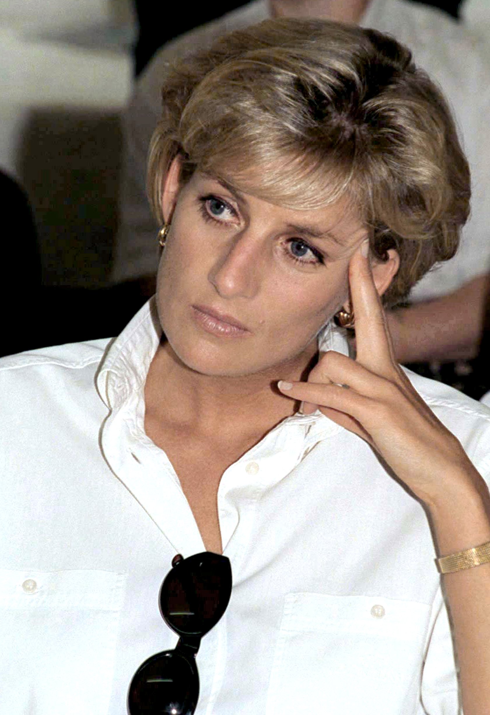 Princess Diana wearing a white collared shirt accessorized with sunglasses in Angola