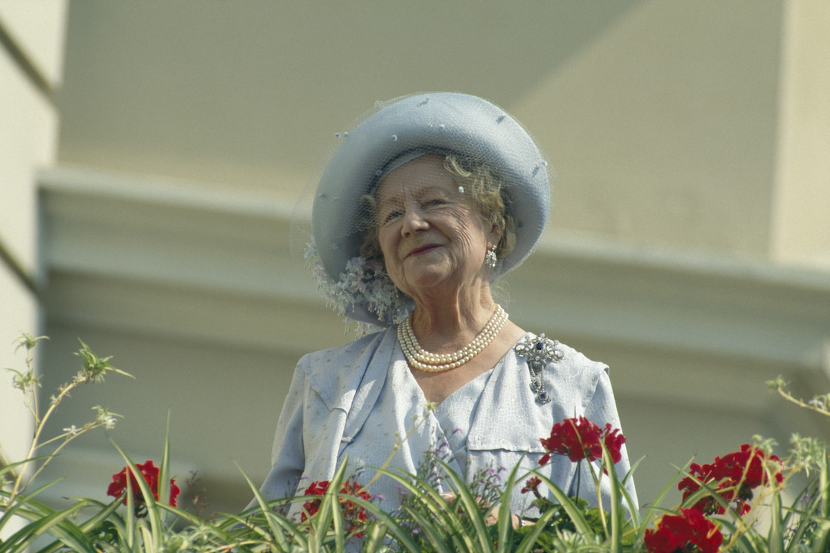 Queen Mother smiling, standing on a balcony