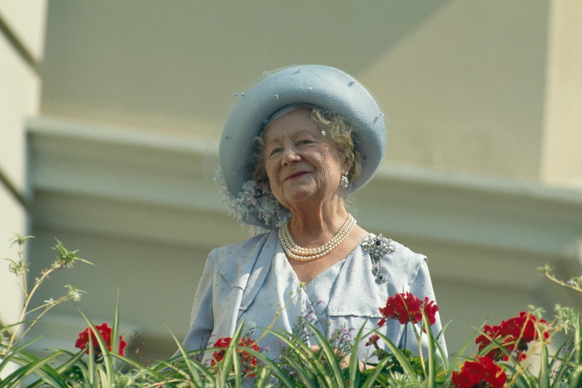 Queen Mother smiling, standing on a balcony