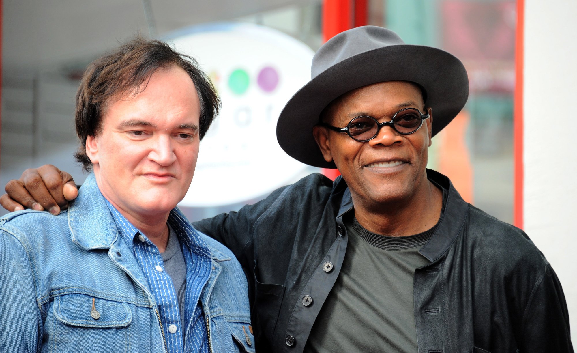 Quentin Tarantino and Samuel L. Jackson at the Hollywood Walk Of Fame smiling with Jackson's arm around Tarantino