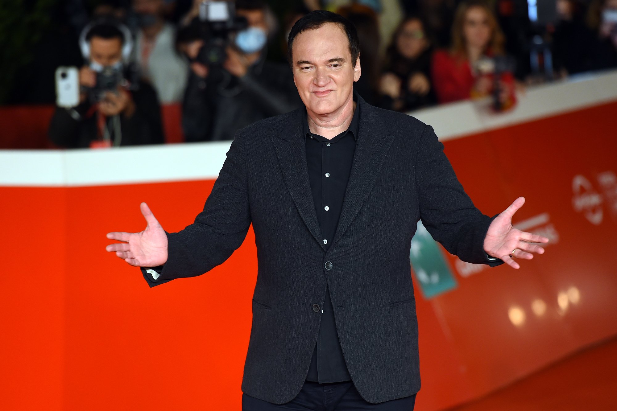 Quentin Tarantino at the Rome Film Festival holding his arms open