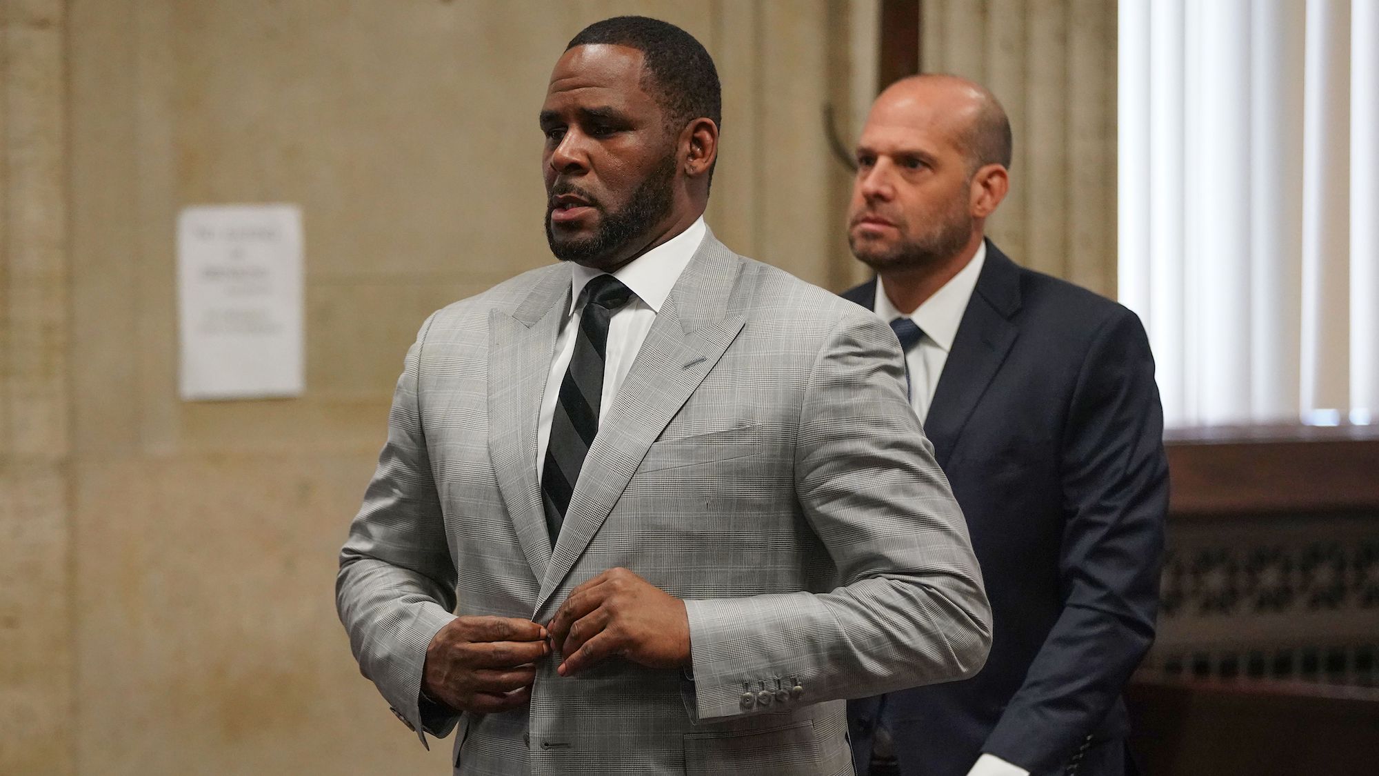 R. Kelly buttons his jacket in court
