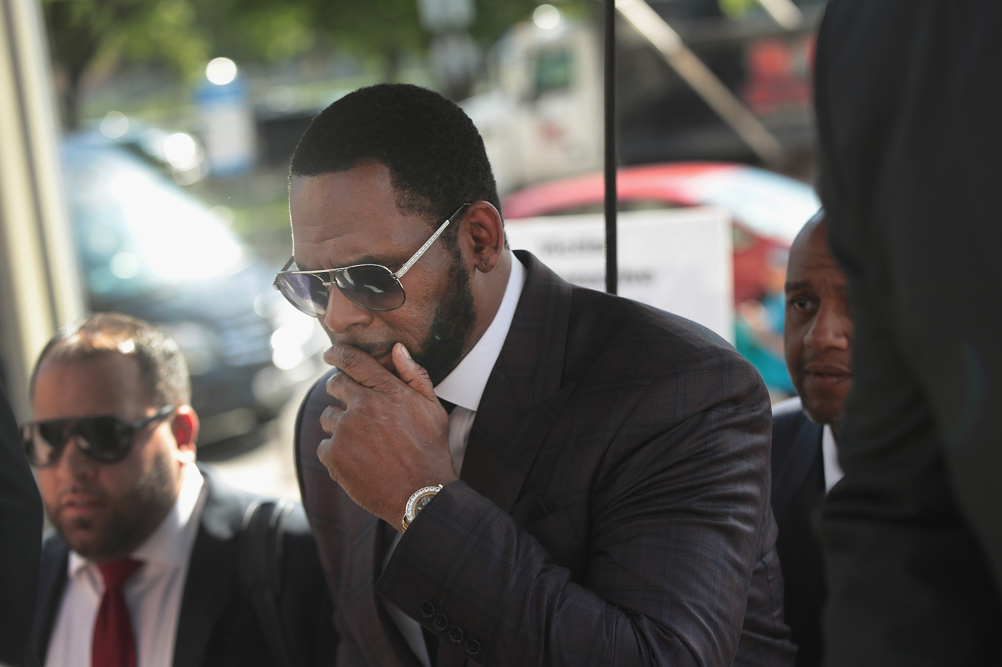 R. Kelly covers his mouth entering the courthouse