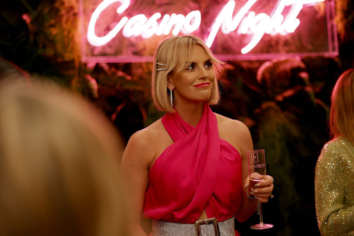 RHOSLC star Whitney Rose seen here in a pink dress holding a glass of champagne.