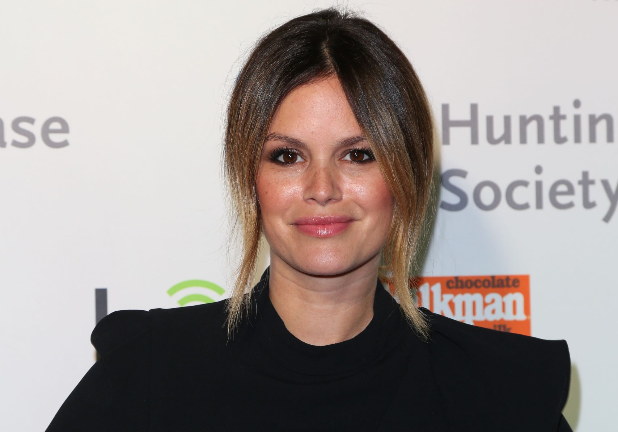 Rachel Bilson dressed in black in front of a white background.