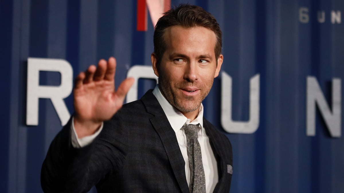 Ryan Reynolds, who starred in an Amityville Horror remake, waves in a suit. 