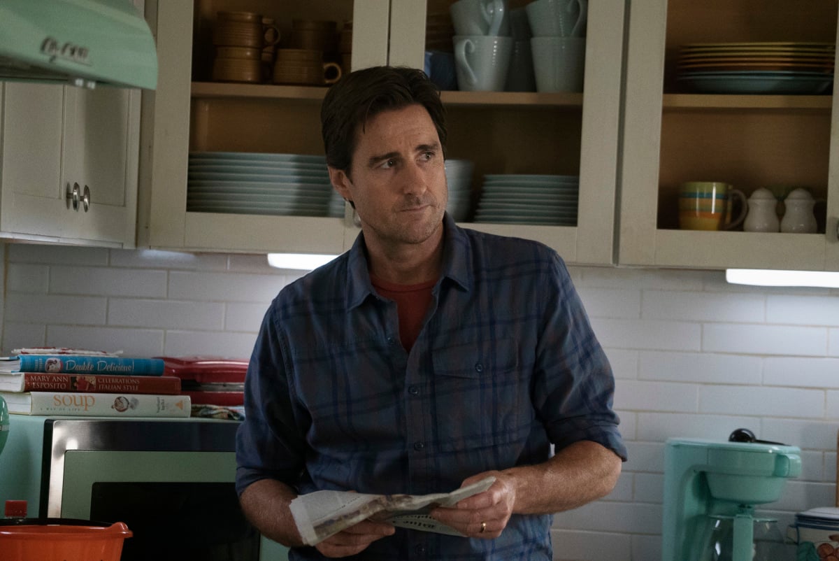 'Stargirl' Season 2 Episode 9 actor Luke Wilson, in character as Pat Dugan, wears a blue plaid button-up shirt over a red shirt.