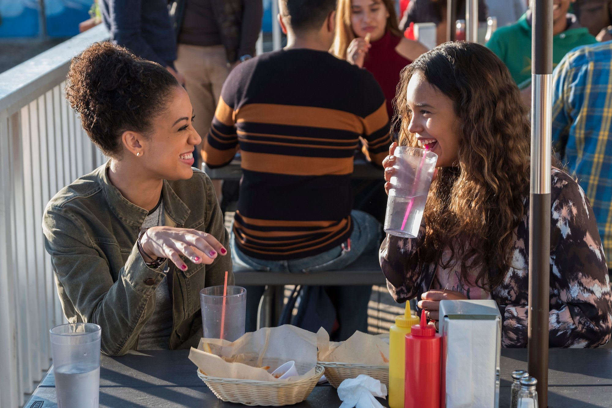Samantha Logan, and Alisha Boe eating food and talking in '13 Reasons Why' Season 2.