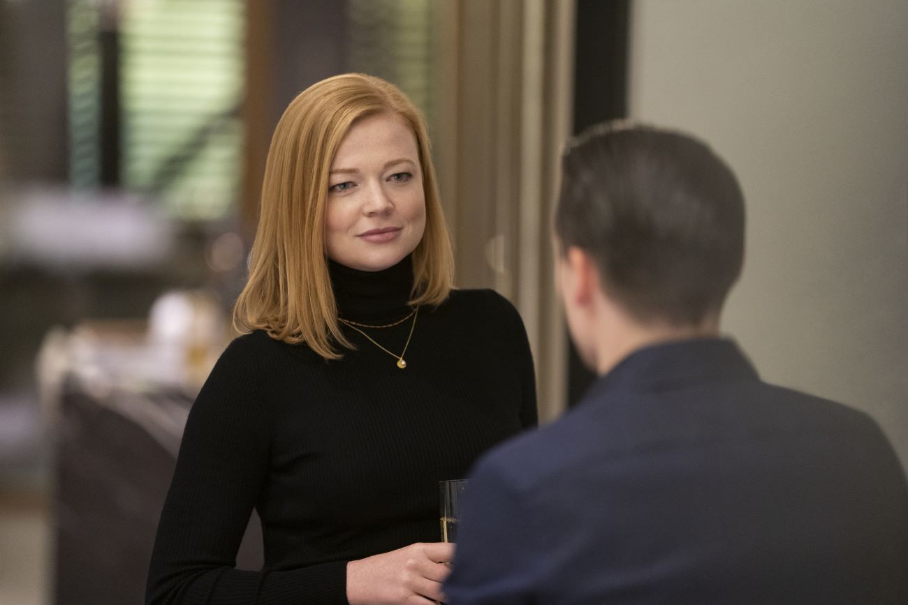 Sarah Snook wears a black turtleneck and talks to Kieran Culkin in Succession.