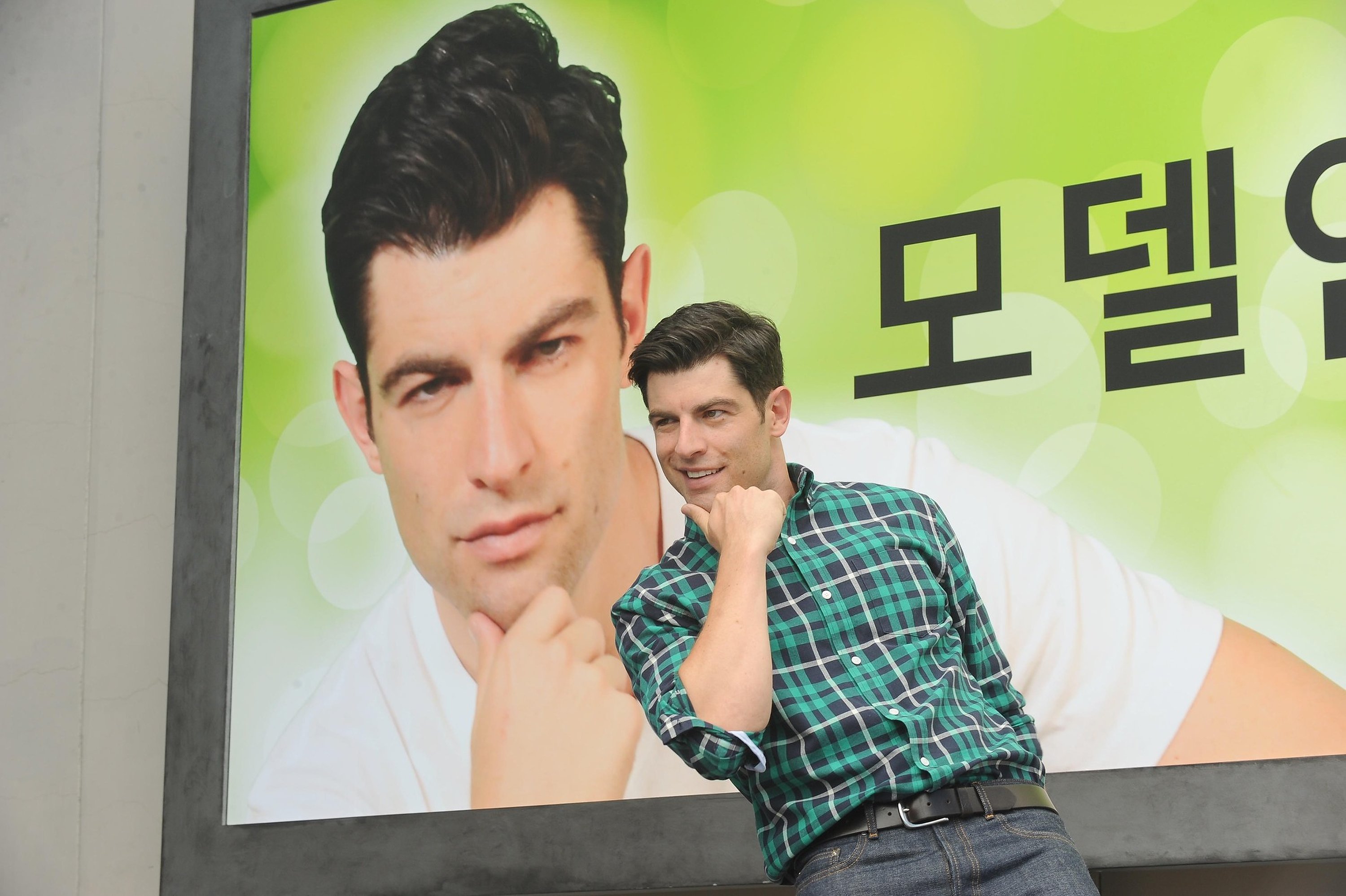 Max Greenfield as Schmidt poses in front of a billboard during an episode of 'New Girl'