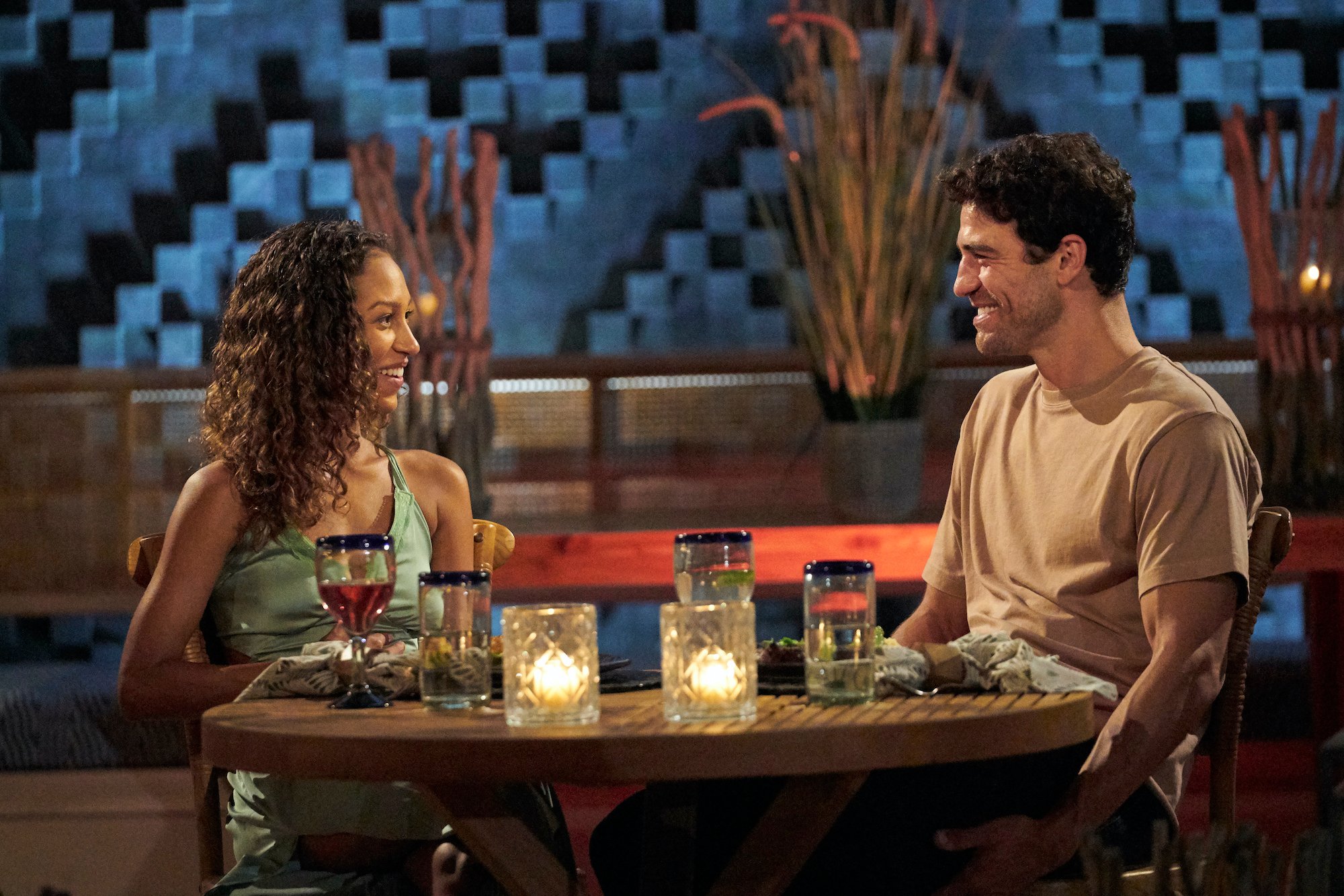 Serena Pitt sits at a table smiling with Joe Amabile just before their engagement on 'Bachelor in Paradise'