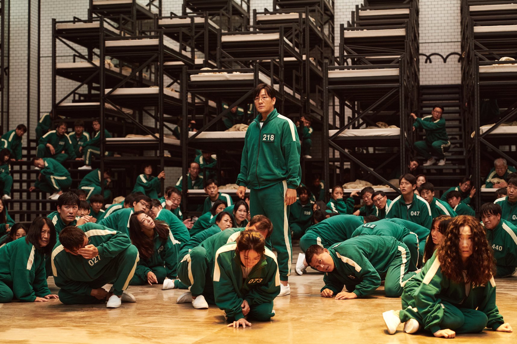 The 'Squid Game' cast on the warehouse set with bunkbeds in the background
