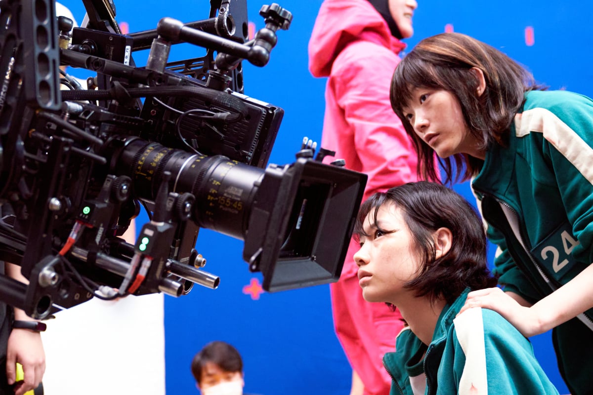 The Squid Game cast get up close to the camera during filming. HoYeon Jung as Sae-byeok and Lee Yoo-mi as Ji-yeong.