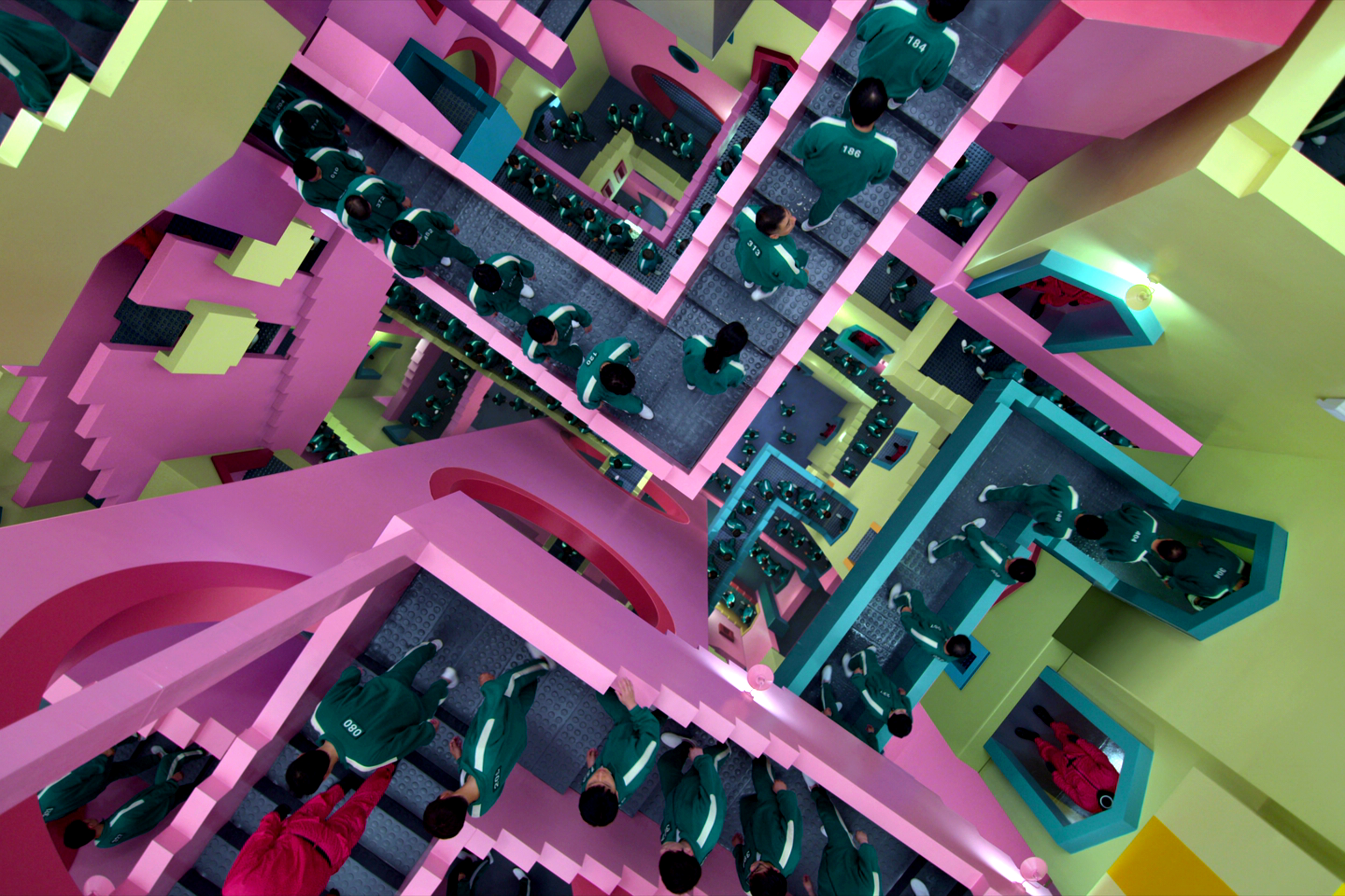 Players walk in the complicated multi-colored staircase in Squid Game.
