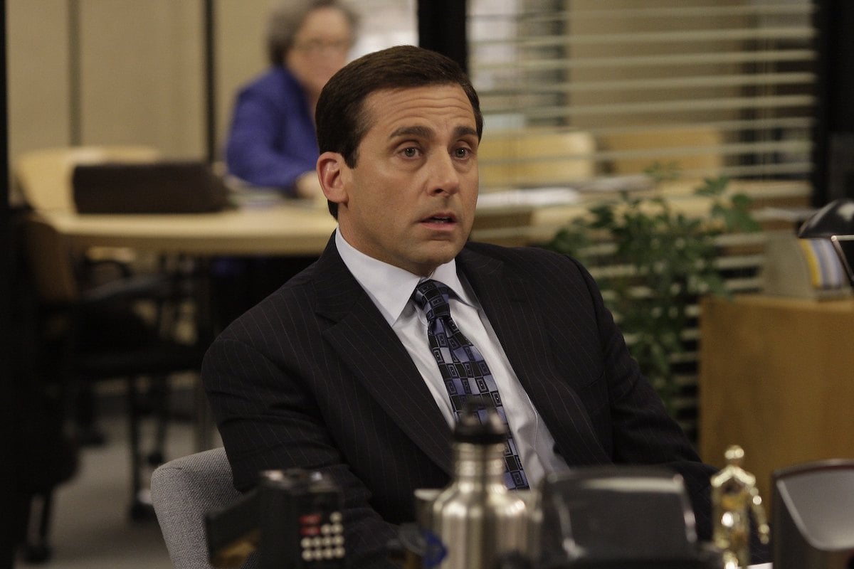 'The Office' cast member Steve Carell as Michael Scott sitting at a desk in a suit