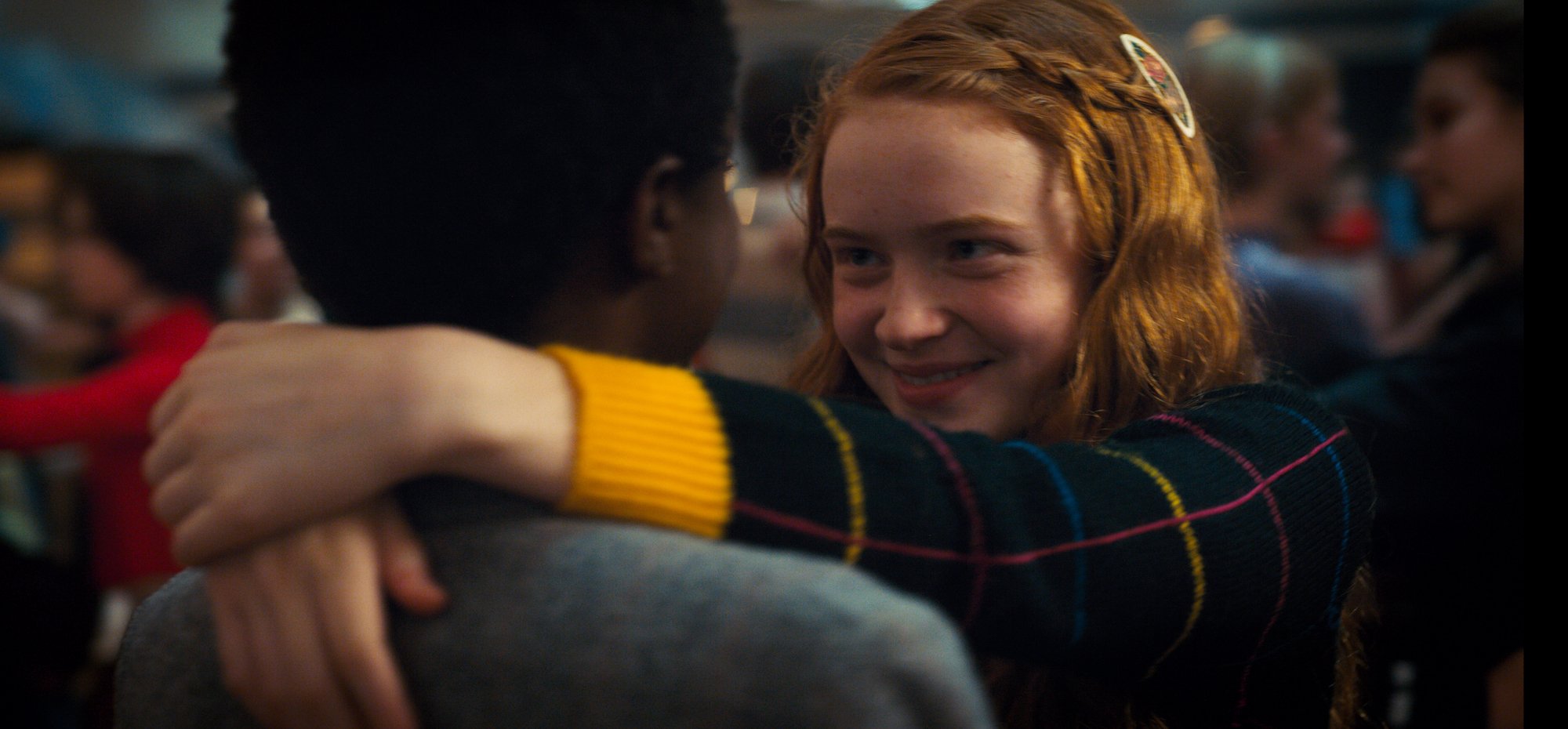 Lucas and Max dancing together at the Snowball in a production still of Stranger Things Season 2.